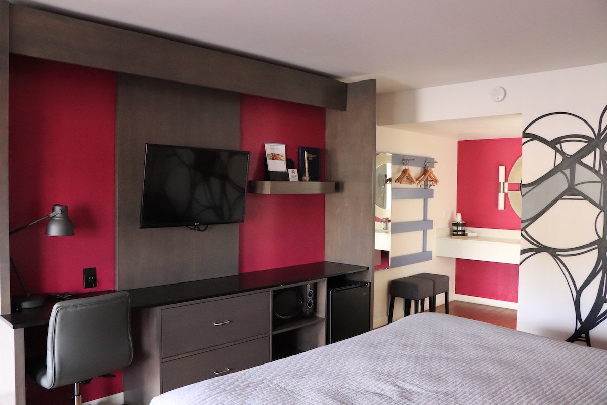 1 King Bed — TV wall unit with desk, microwave, mini-fridge, and vanity area