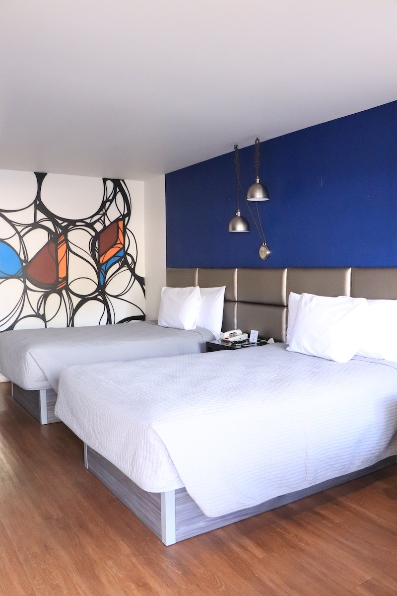 2 Double Beds — blue accent wall with hardwood floors