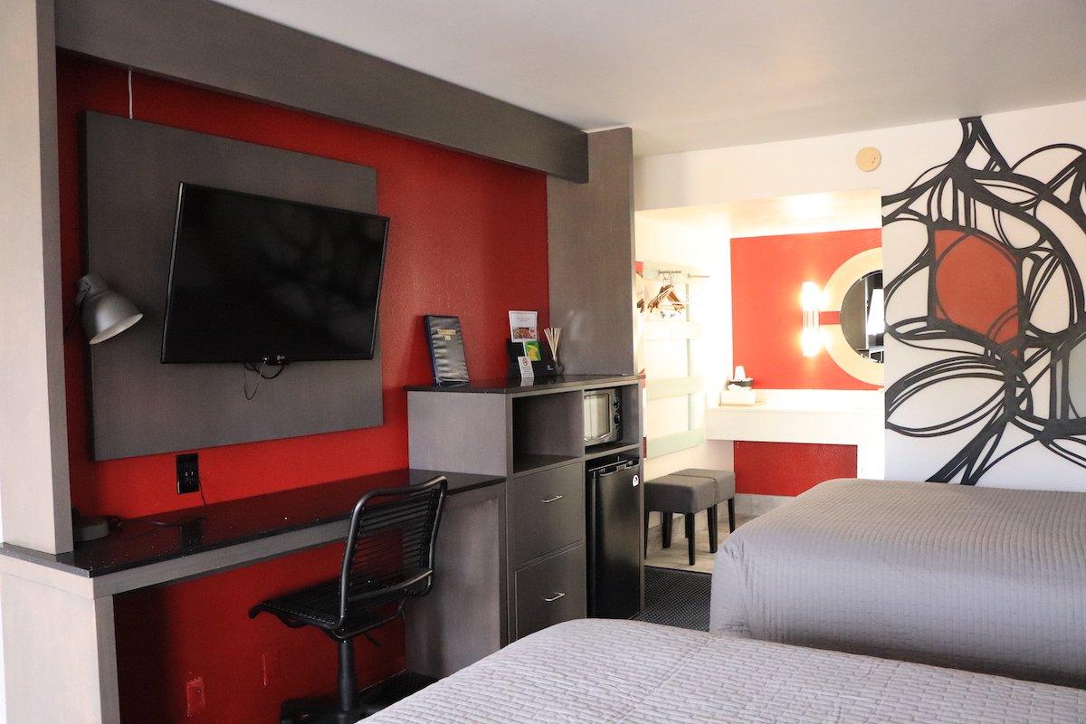 2 Double Beds — red accent wall with round mirror